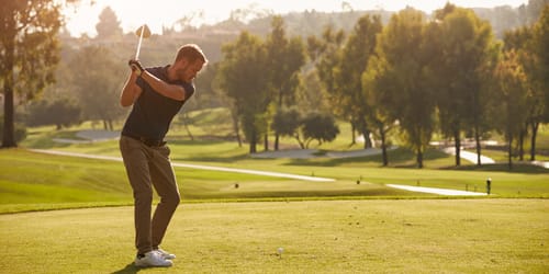 Male Golfer Lining Up Tee Shot On Golf Course